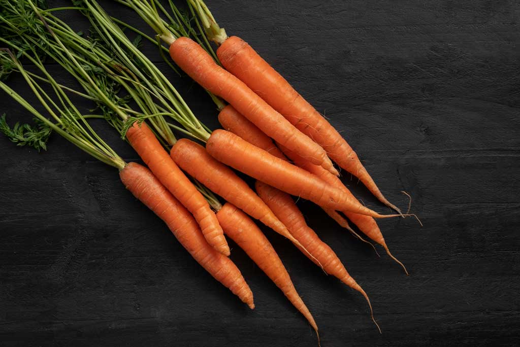 The image shows carrots as a high fiber food.